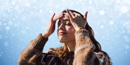 A girl applying sunscreen on her face during winter to protect her skin from UV rays.